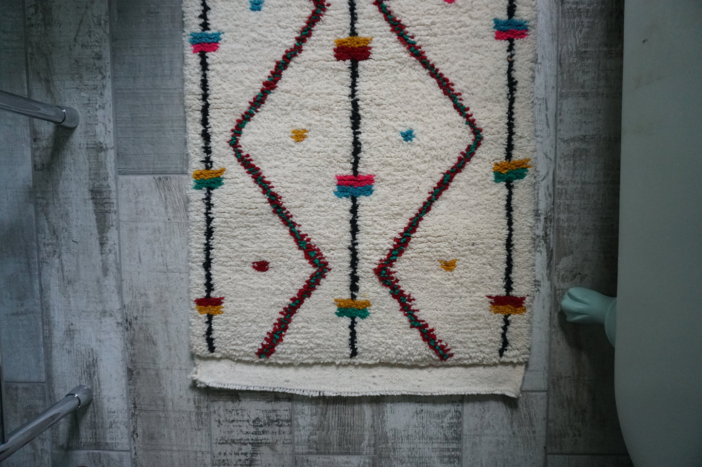 Decorative rug with geometric pattern on a wooden floor