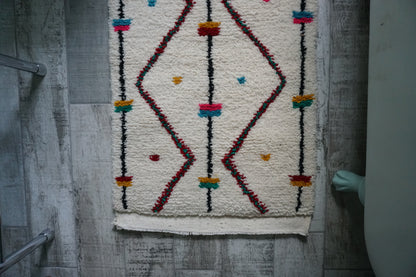 Decorative rug with geometric pattern on a wooden floor
